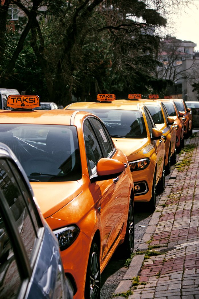 gallery-6 Close-up of multiple yellow taxis on a cobblestone street, hinting at lively urban transportation.