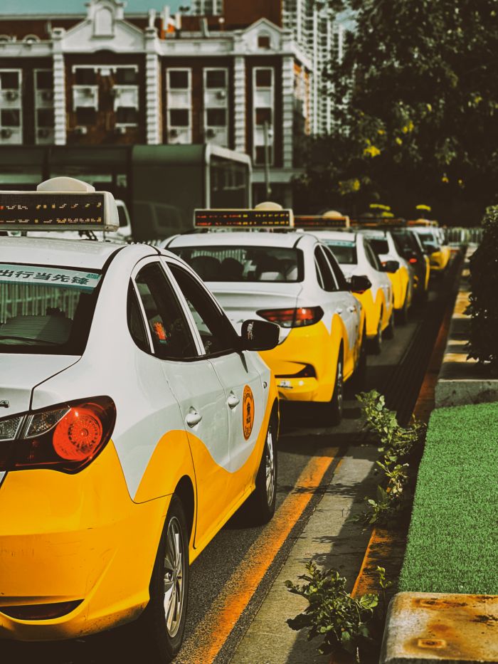 gallery-5 A row of yellow taxi cabs waits on a city street, providing urban transportation.