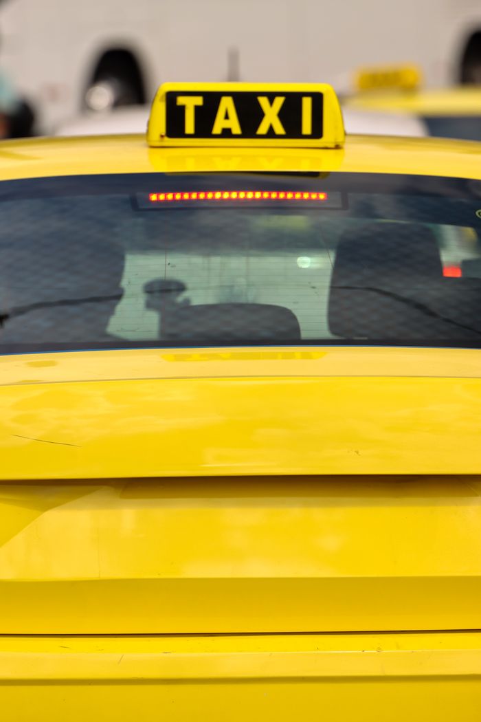 gallery-3 Close-up of a yellow taxi in Athens, Greece, highlighting the bright sign and urban setting.