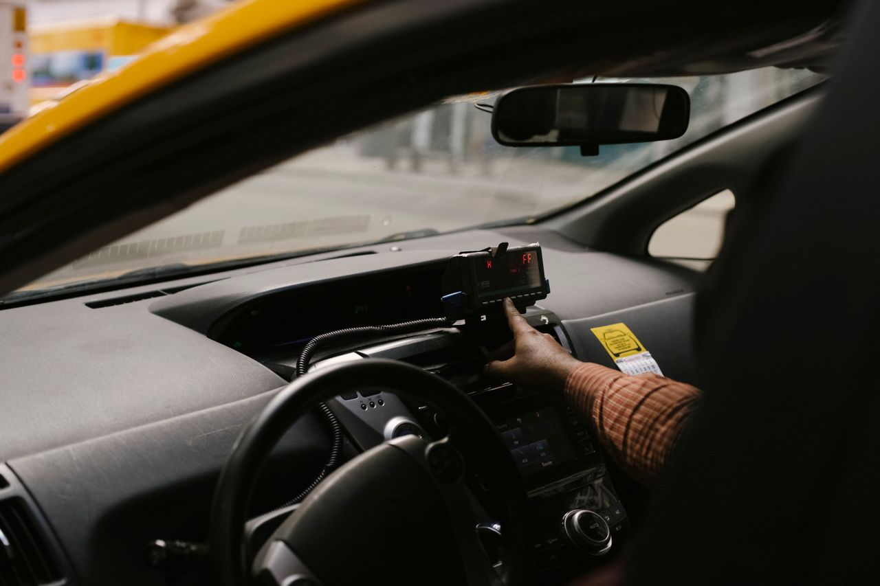 services-03 Anonymous ethnic male driver with steering wheel using GPS navigator to search direction for drive on street in city during work